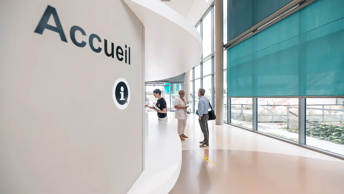 Accueil d’hôpital avec patients et personnel à l’information