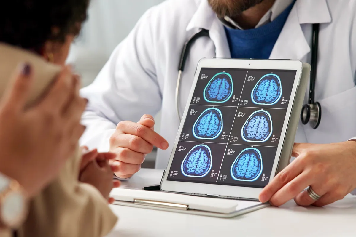 Consultation en neurologie avec présentation d’images d’imagerie cérébrale sur tablette numérique pour expliquer un diagnostic ou un suivi neurologique au patient