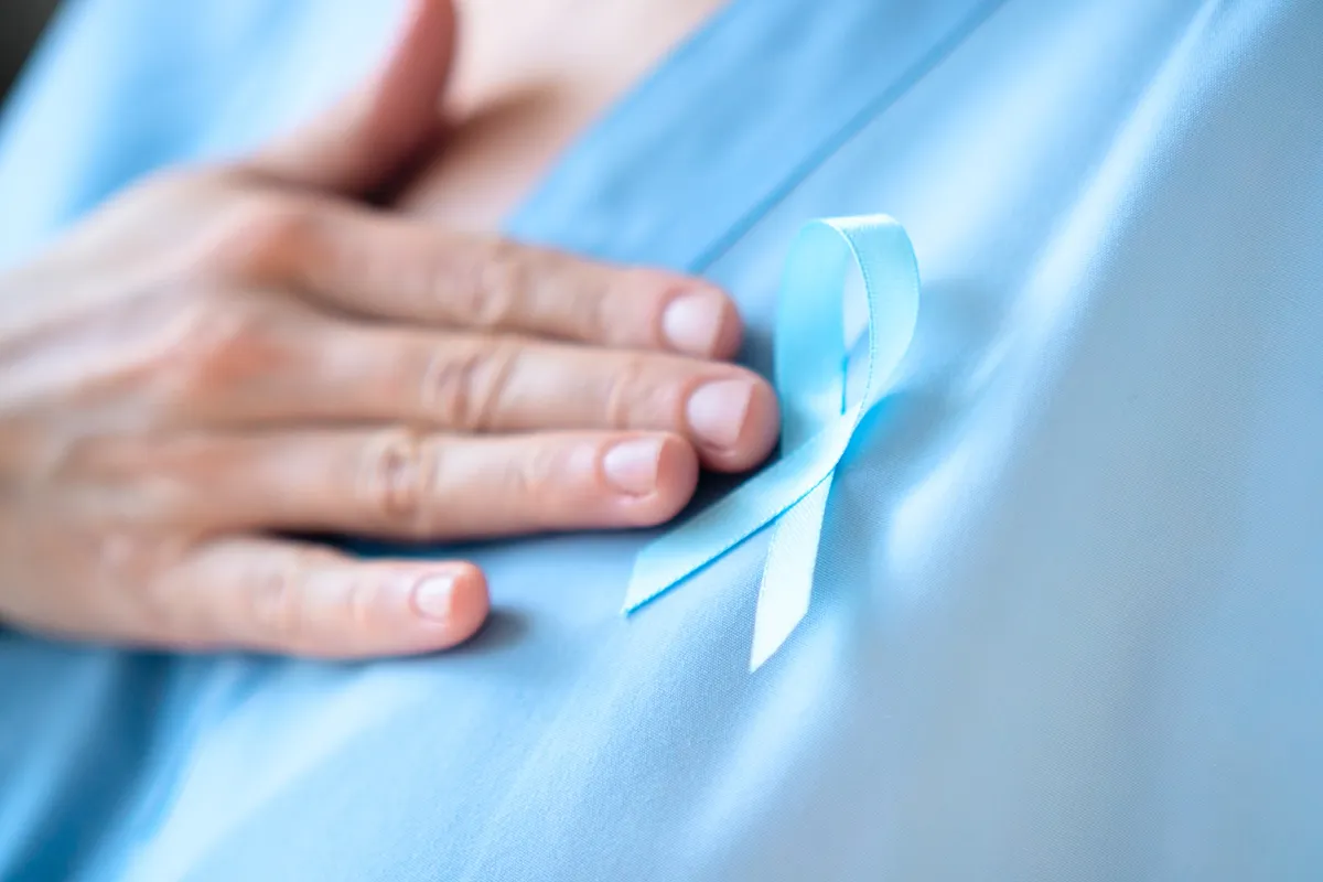 Ruban bleu contre le cancer sur la poitrine d'un soignant. Service d'Oncologie au Centre Hospitalier de Carcassonne