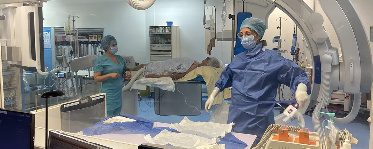 Équipe soignante en salle d’intervention avec patient installé sur la table.